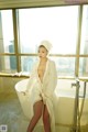 A woman in a white robe sitting in a bathtub.