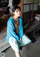 A woman sitting on a wooden bench in a room.