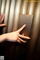 A woman's hand is pressing a button on an elevator.