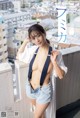 a japanese woman in shorts and a white shirt is posing on a balcony