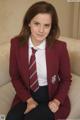 A woman in a school uniform sitting on a couch.