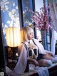 A woman sitting on a window sill next to a lamp.