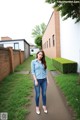 A woman standing in front of a brick building.